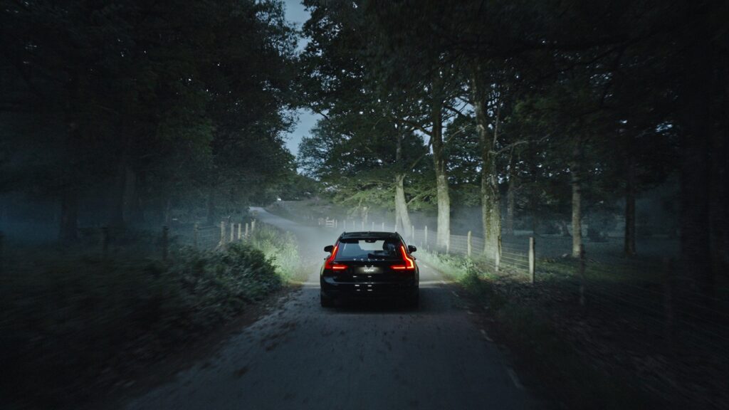 Car on a dark forest road lit by Luxtar Twilight
